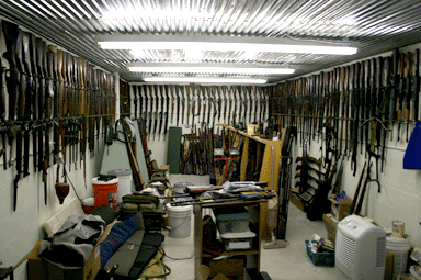 A vault room containing different guns and survival gear against the walls.