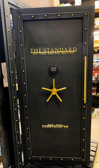Custom Black Brass Steampunk Titan Vault Door with gold text across the front and a gold handle. Custom Black Brass Steampunk Titan Vault Door with gold text across the front and a gold handle.