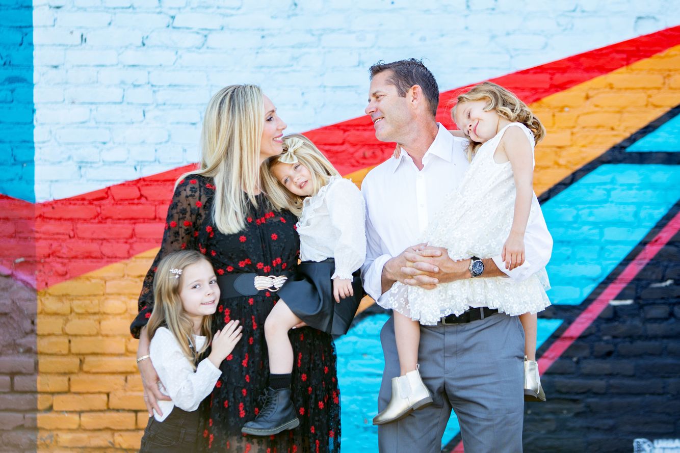 Mom and Dad embracing their children while looking at each other in a photo shoot at RiNo Arts District. 