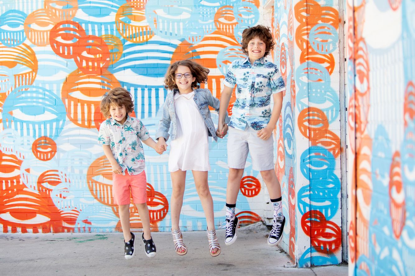 Kids jumping together at a photoshoot in Denver's RiNo Arts District.