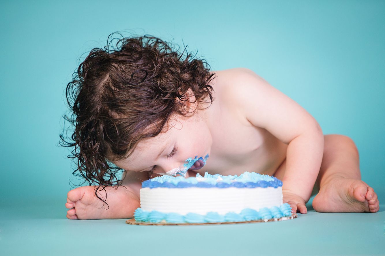 1 year old leaning over and eating cake in a Cake Smash Session at our Denver Portrait Studio. 