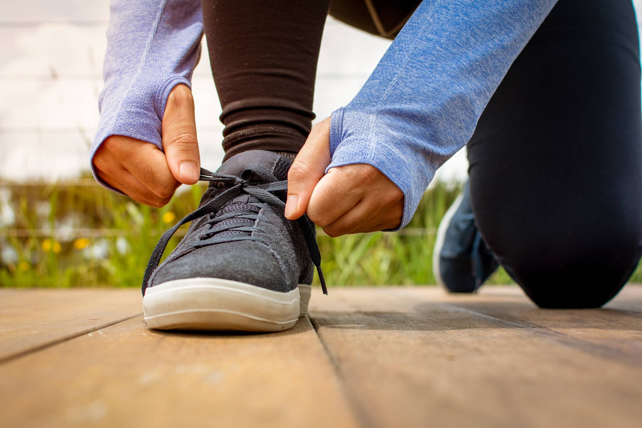 A person tying their sneakers Anodyne Shoes