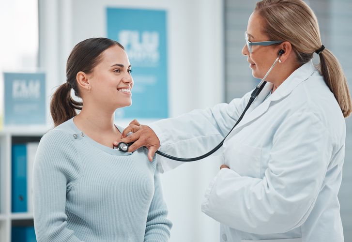 A doctor checking a patient's heart rate Health Screenings
