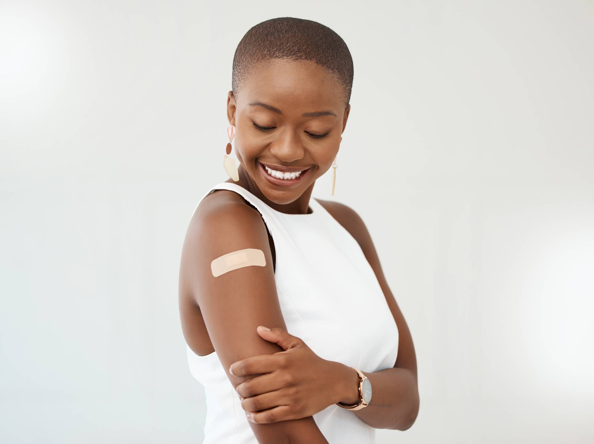 Woman with a bandaid on her upper arm. Immunizations