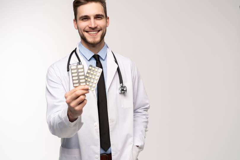 Male pharmacist holding pills Pharmacist with pills