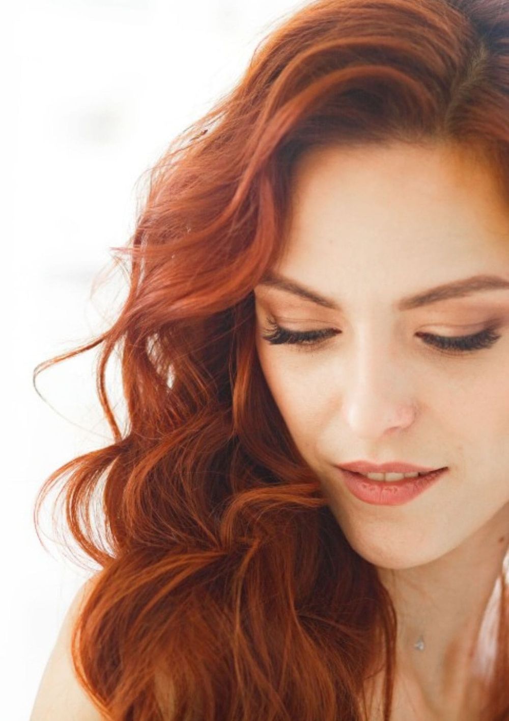 A woman with red hair looking down