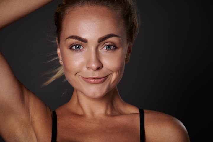 Headshot-of-a-beautiful-European-woman-with-fresh-clean-glowing-tanned-skin_-smiling-looking-at-camera-isolated-over-dark-background.-Body-positivity_-self-acceptance_-confidence-concept-1389280901_212.jpeg