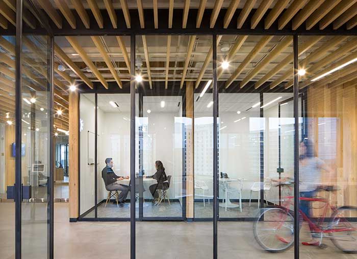 A look inside MF architecture. Glass windows, a conference room, and someone walking their bike 7