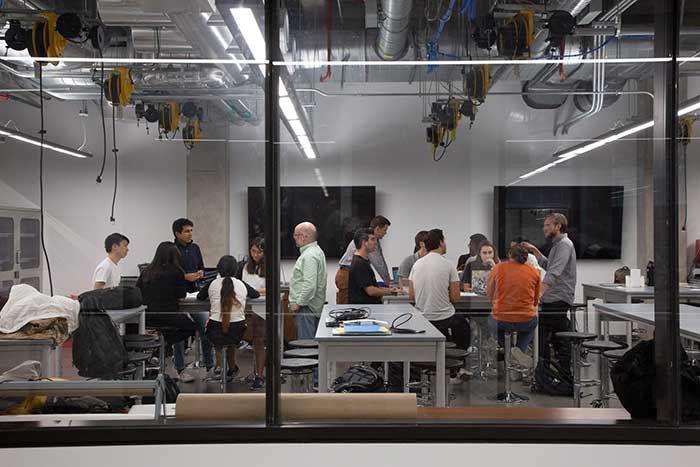 Group of people talking at tables behind a glass wall 7