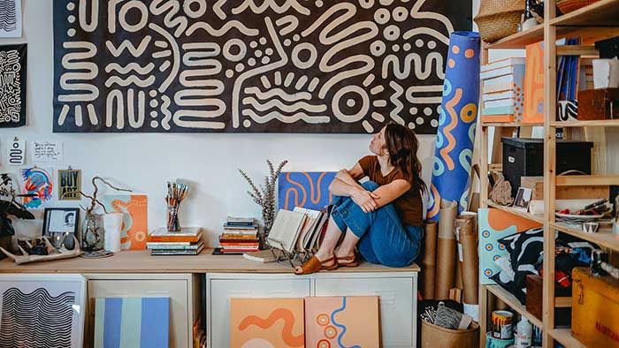 Emily Eisenhart looking up at one of her art pieces in her studio 4