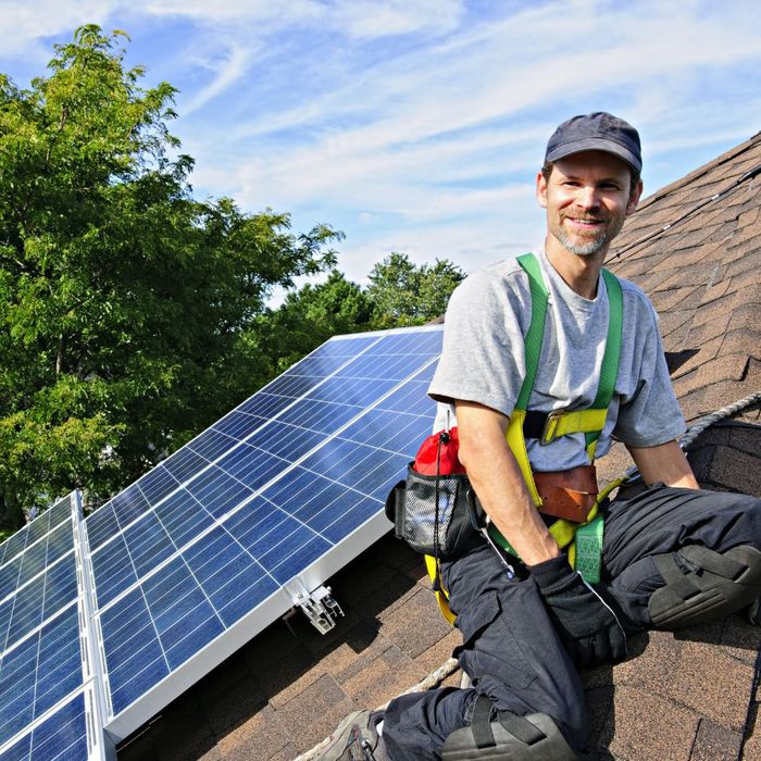 a worker on a roof working on solar panels