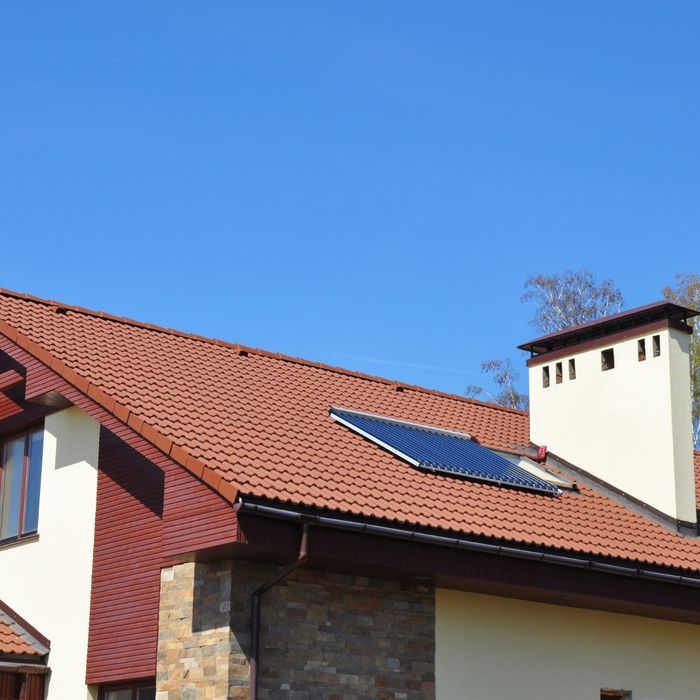 House with a single solar panel on its roof