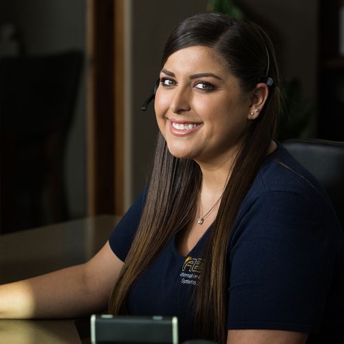  receptionist smiling and sitting at a desk