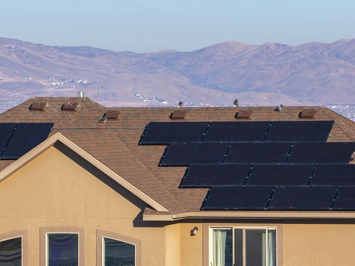 Image of midwestern home with solar panels in front of mountain range