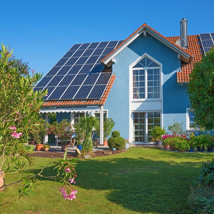 Blue house with several solar panels on its roof