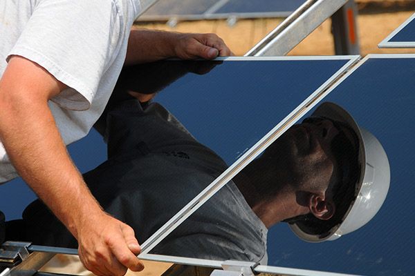 Photo of a man working on a solar system