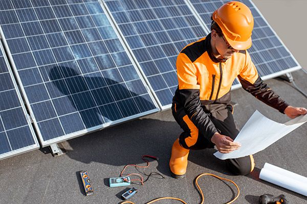 Photo of a man working on a commercial solar system