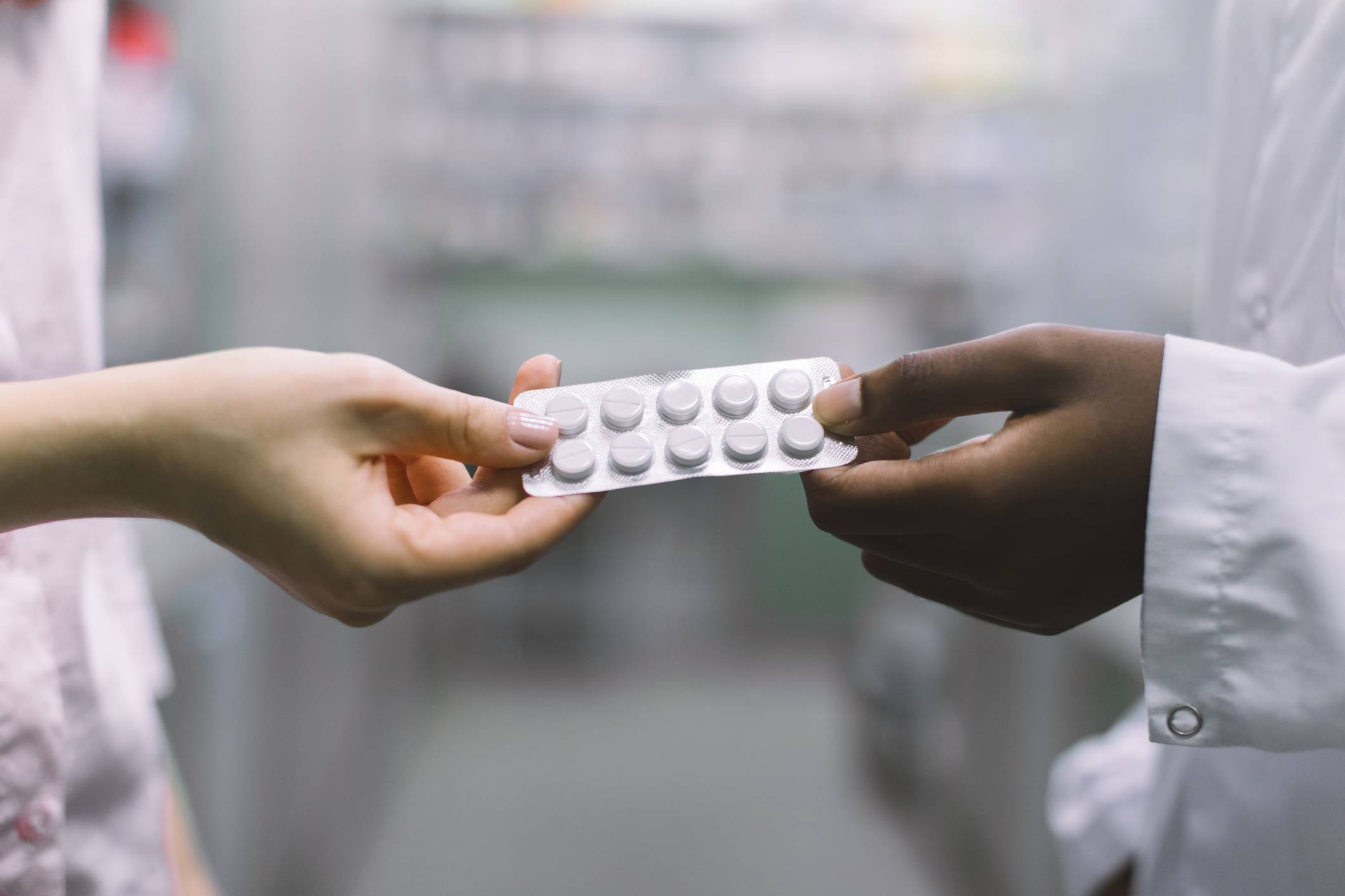 Pharmacist handing medication to patient Medication Therapy Management