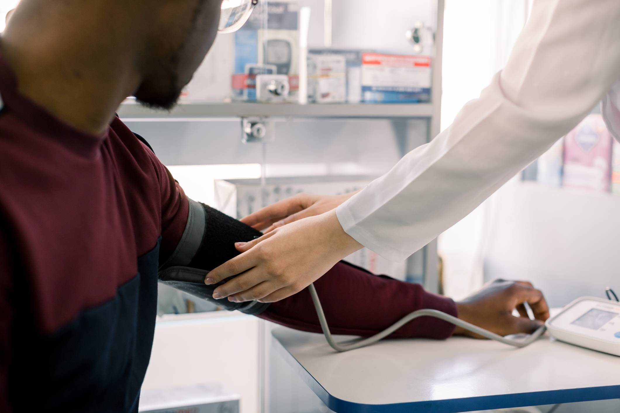 Pharmacist taking persons pulse Pharmacy