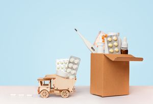 first-aid-kit-wooden-car-with-pills-table-blue-background.jpg