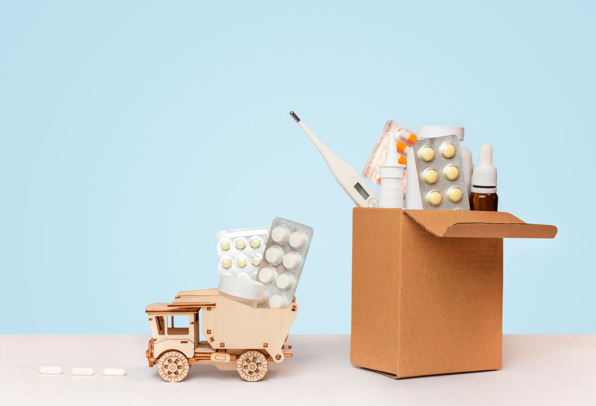first-aid-kit-wooden-car-with-pills-table-blue-background.jpg