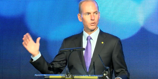 A man speaking in front of an led video wall display