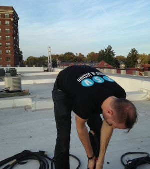 Joel Dodson running cable on a rooftop for CWE Halloween