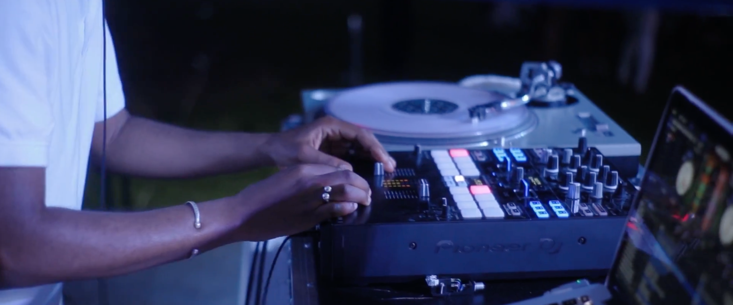A DJ spinning at an outdoor event