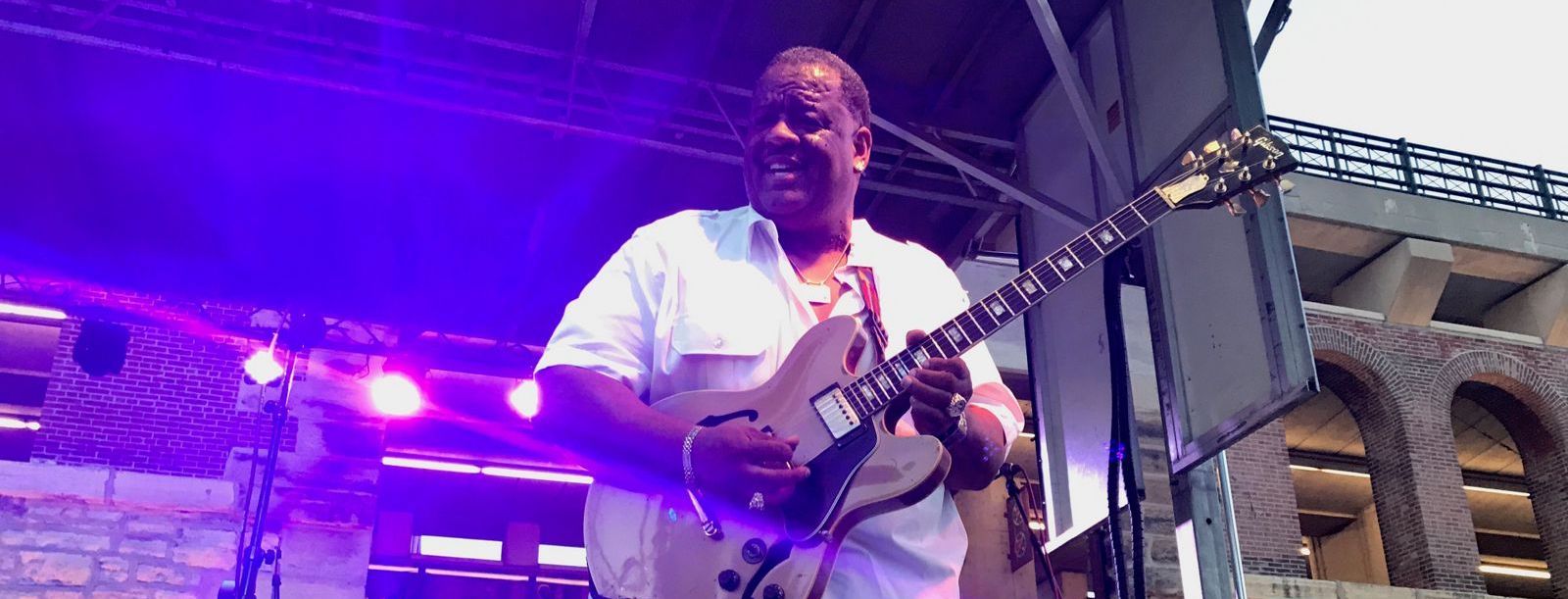 A man playing the electric guitar at a St. Louis concert