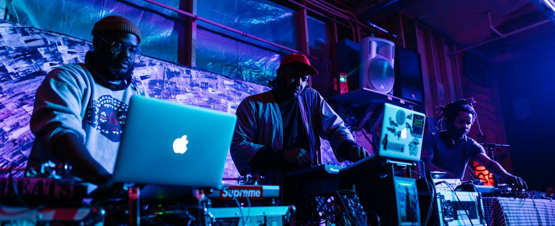 Three DJs spinning at a party