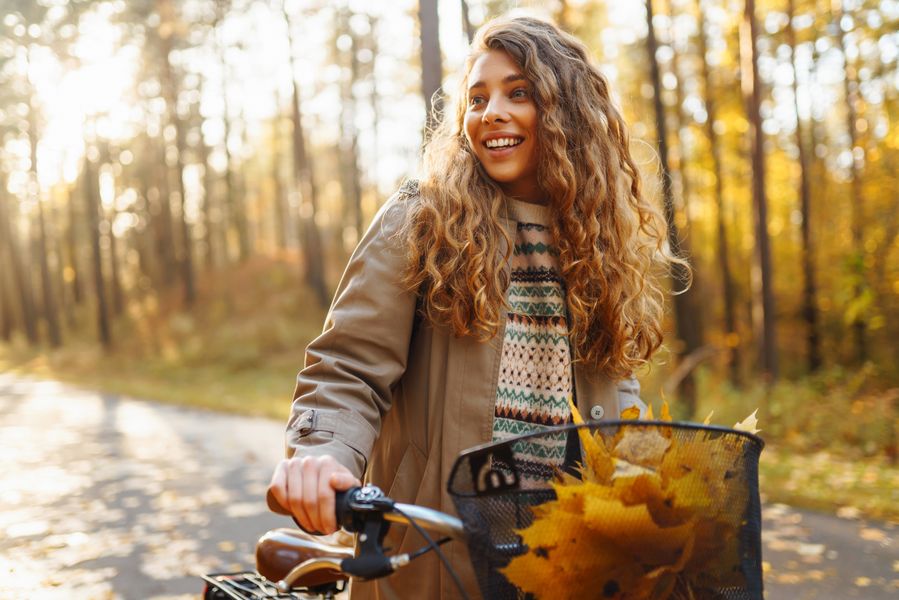 happy-woman-with-curly-hair-rides-bicycle-in-sunny-2023-08-19-04-28-50-utc.jpg