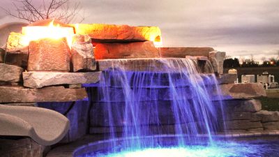hand crafted stone waterfall with custom slide and automated fire features