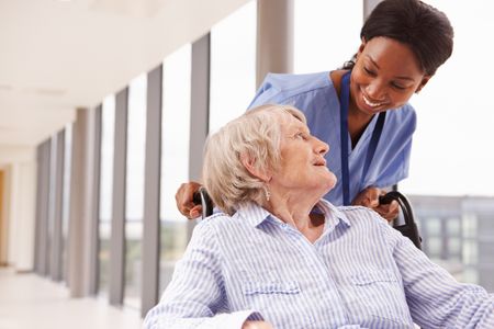 Nurse pushing an elderly patient in a wheelchair Transition of Care