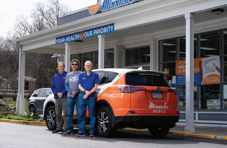 Pharmacy staff standing by a delivery car Complimentary Delivery