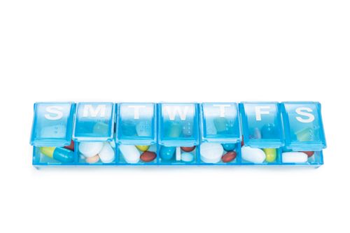 Pills in a blue pill organizer Medication Adherence
