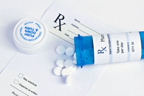 Prescription bottle next on a prescription pad MTM