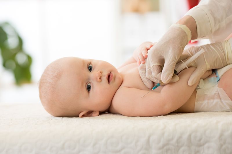 Pediatrics doctor giving a child vaccine injection