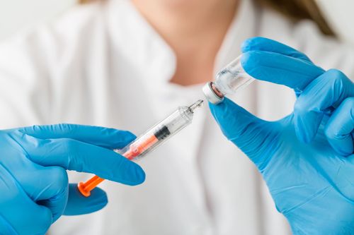 Pharmacist filling a vaccine syringe