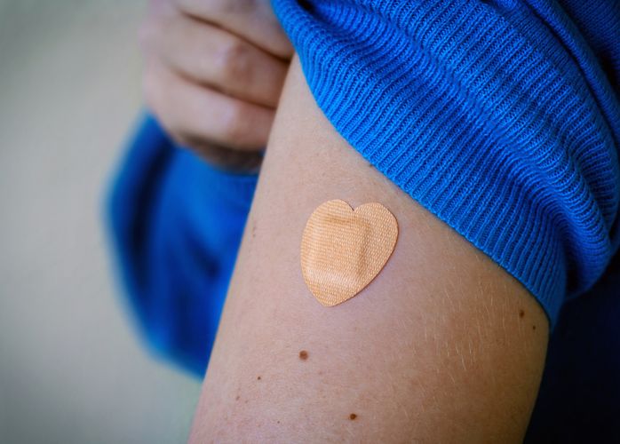 Person showing a heart shaped band aid on their arm Immunizations