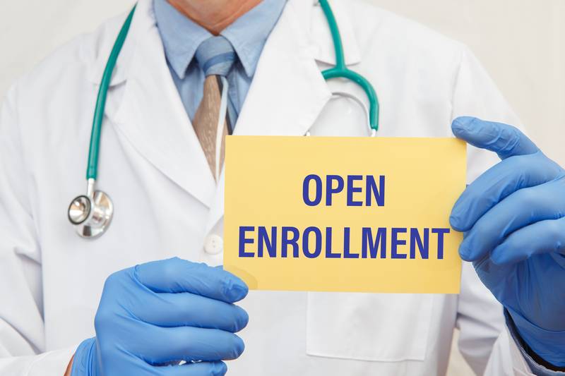 Healthcare professional holding an open enrollment card Medicare Open Enrollment