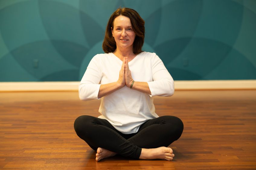 A gentle yoga teacher teaching senior yoga and chair yoga and yoga for homeshcoolers