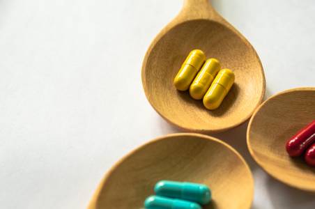 Colorful pills on spoons Pharmacy services