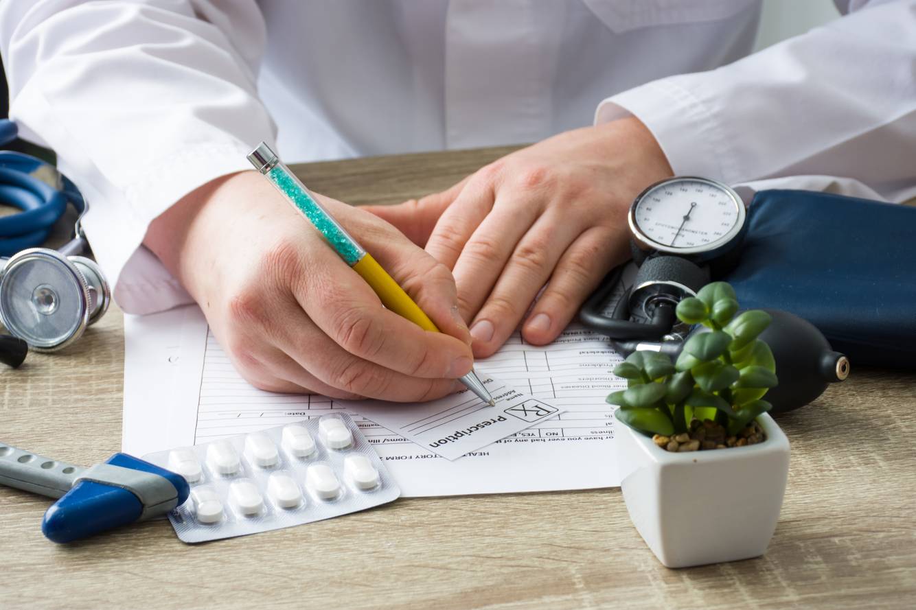 Image of a healthcare professional writing a prescription Medication Therapy Management