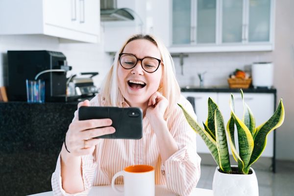 happy-girl-sitting-at-home-kitchen-and-holding-videocall-young-woman-using-smartphone-for-video-call_t20_9km87Y.jpg