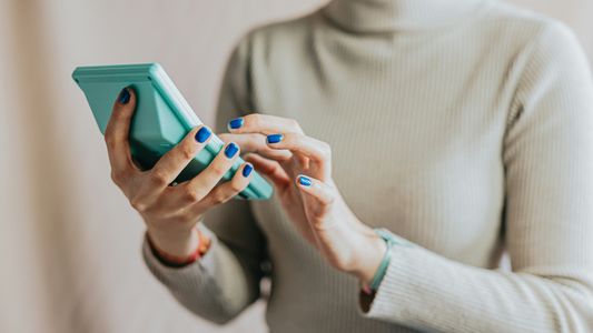 Close-up of woman holding a blue calculator