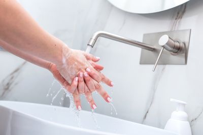 woman-washing-hands-with-foam-soap-hygiene-RBRSMVE.jpg