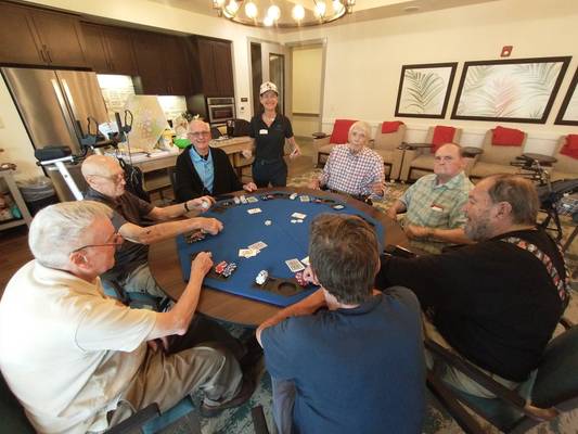 A group of residents gather to play cards. Starling Senior Living Residents