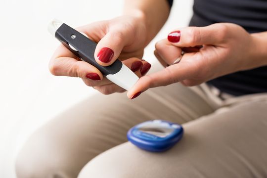 Woman checking blood glucose with a meter