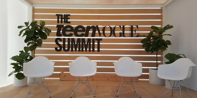 Teen Vogue Summit Panel Stage with white chairs and plants