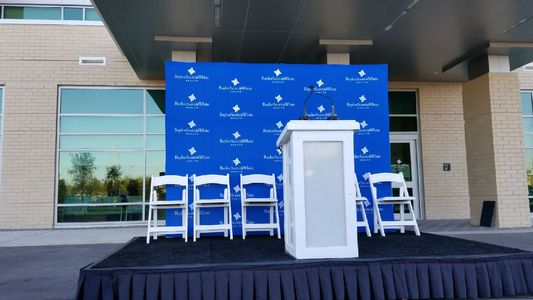 Small press conference stage with podium and branded step-and-repeat